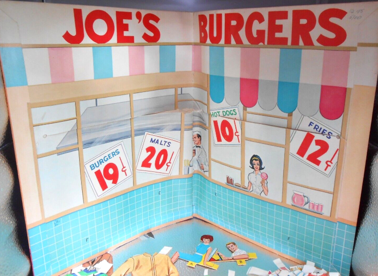 A folder stands open. Large red lettering along the top reads JOE'S BURGERS. Below that is a striped awning, followed by a wall of windows with signs for: Burgers, 19 cents; malts, 20 cents; hot dogs, 10 cents; fries, 12 cents. A male employee is drawn near a range hood, and a female employee stands inside on window with burgers and colas on a tray. A pitcher and glasses at another window are filled with pink fluid. Below waist level of the characters is a wall of aqua tile. On the surface below the folder are, among some partially-visible paper doll clothes, a miniature paper Barbie in a seated position, about half the size of the paper dolls, and a miniature Ken, just from the arm up, at a steering wheel. They are for inserting into a paper car, not shown.